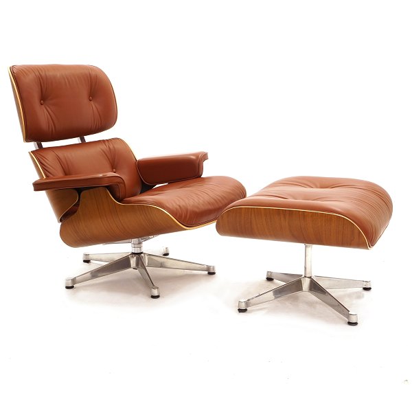 Eames loungechair med skammel designet 1956. Polstret med rød/brunt læder i pæn 
stand. Under sæde plakette fra producenten. Stol: H: 90cm. B: 84cm. D: 70cm